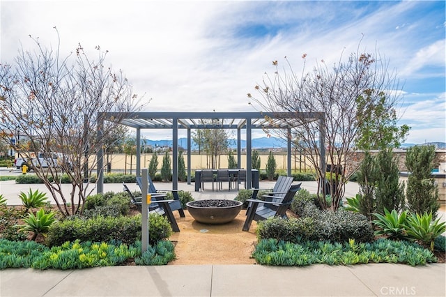 view of community featuring a mountain view, a fire pit, and a pergola