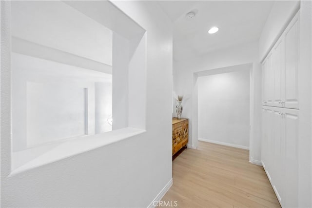 hallway with light hardwood / wood-style floors