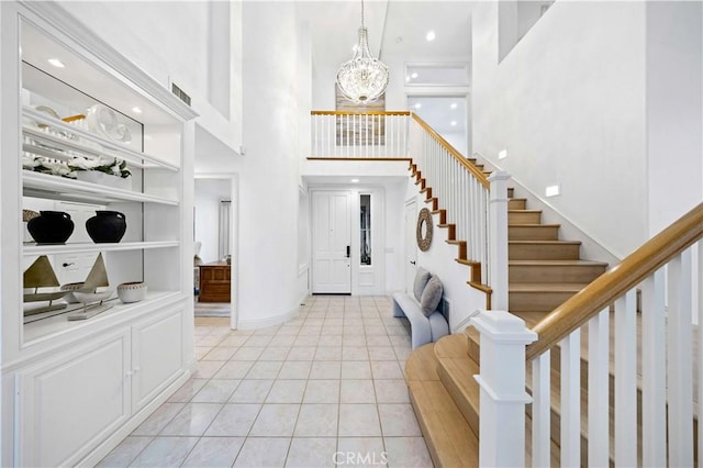 tiled entrance foyer with a notable chandelier and a high ceiling