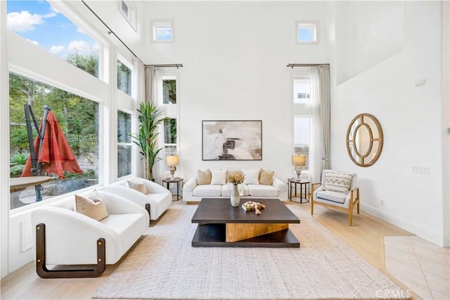 interior space featuring a towering ceiling and light wood-type flooring