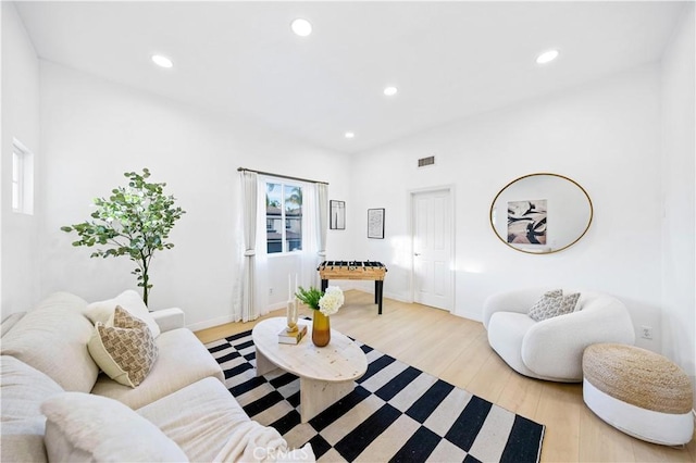 living room featuring a wealth of natural light, light wood-type flooring, visible vents, and recessed lighting