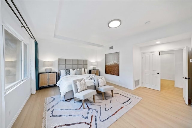 bedroom featuring light wood finished floors, baseboards, and visible vents