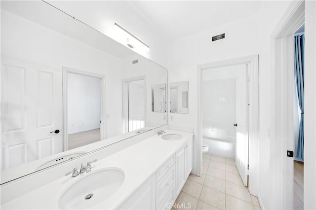 bathroom with double vanity, visible vents, a sink, and tile patterned floors