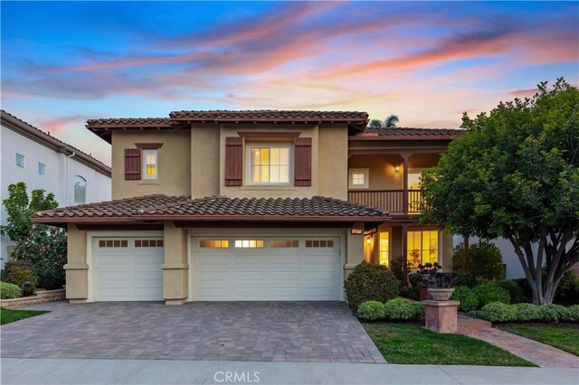 mediterranean / spanish-style home with a balcony and a garage