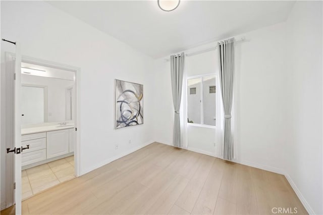 unfurnished room with light wood-style flooring and baseboards