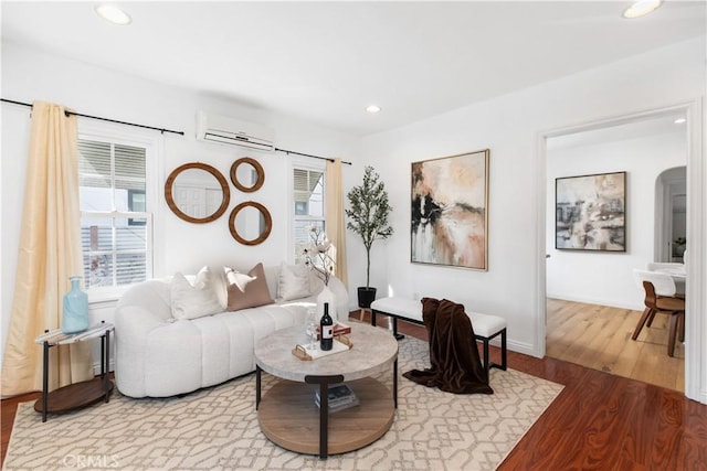 living room with hardwood / wood-style flooring and a wall mounted air conditioner