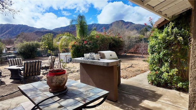 view of patio / terrace with a mountain view, area for grilling, and grilling area