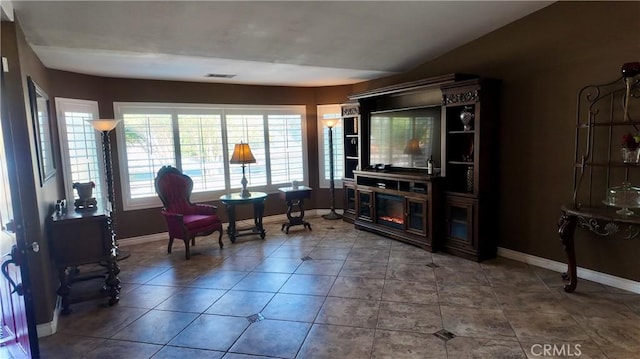 living area with a fireplace and tile patterned flooring