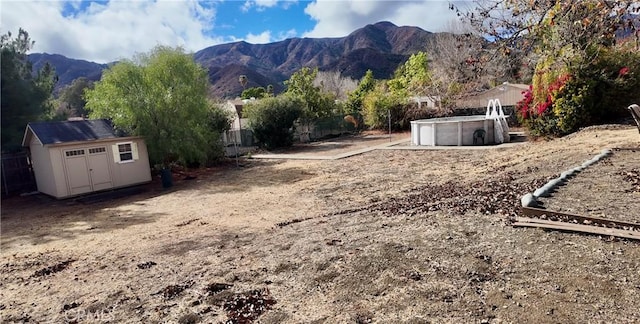 view of yard with a mountain view and a storage unit