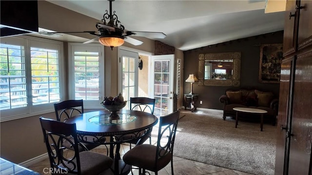 tiled dining area with ceiling fan and vaulted ceiling