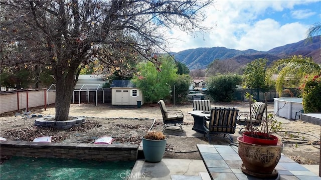 view of patio featuring a storage shed and a mountain view