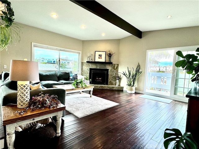 living room featuring hardwood / wood-style floors, a fireplace, and beamed ceiling