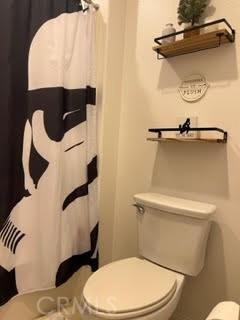 bathroom with toilet and a shower with curtain