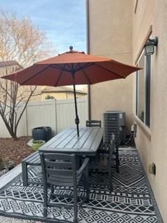 view of patio / terrace with central AC unit, fence, and outdoor dining space