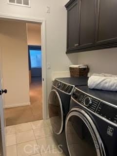 laundry area featuring cabinet space, tile patterned flooring, visible vents, and washer and dryer