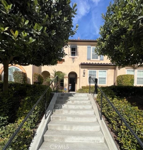 view of front of property featuring stairs and stucco siding