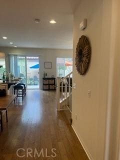 hall featuring stairs, wood finished floors, and recessed lighting