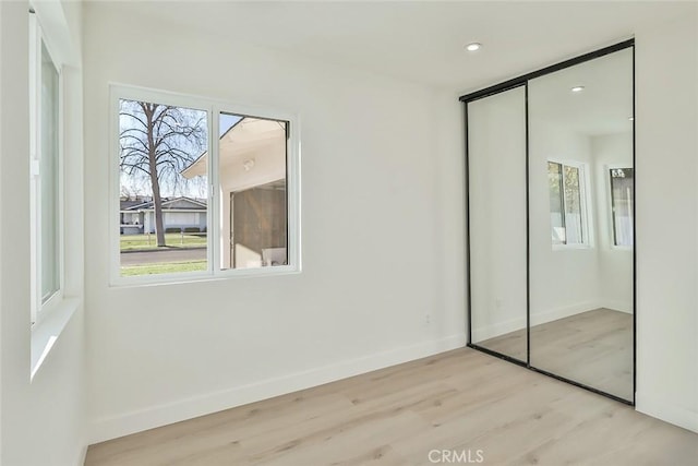 unfurnished bedroom with a closet and light wood-type flooring