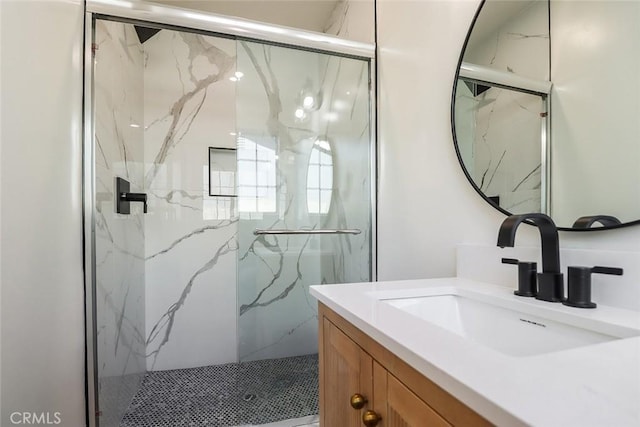 bathroom with a shower with shower door and vanity