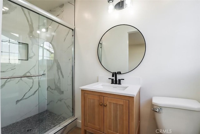 bathroom featuring toilet, a shower with door, and vanity