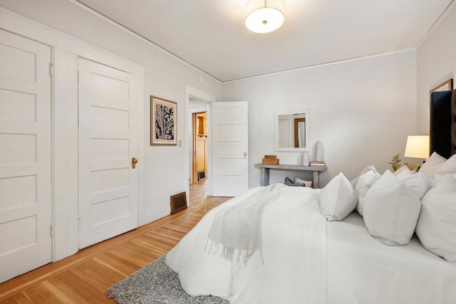 bedroom with ornamental molding and wood-type flooring