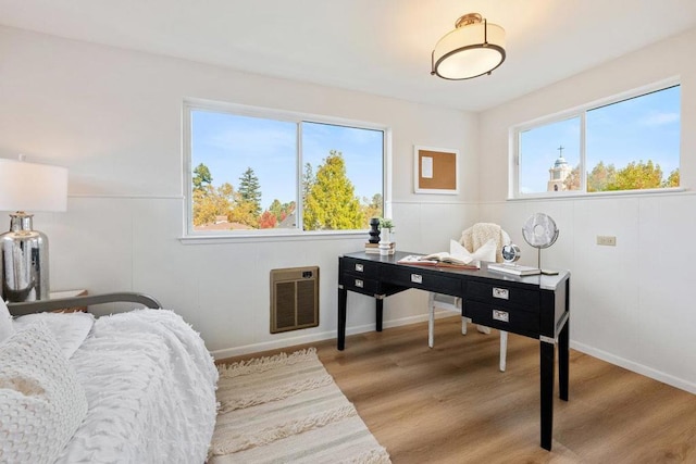 office with heating unit and light hardwood / wood-style floors