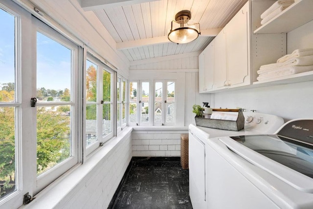 clothes washing area featuring cabinets, a healthy amount of sunlight, and separate washer and dryer