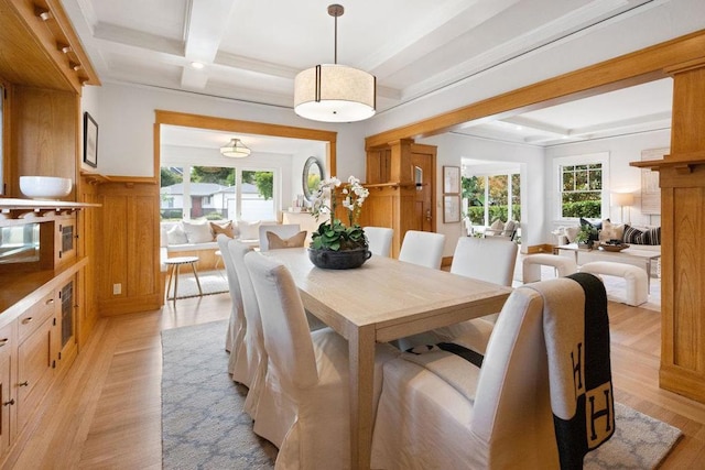 dining area with coffered ceiling, plenty of natural light, beam ceiling, and light hardwood / wood-style floors