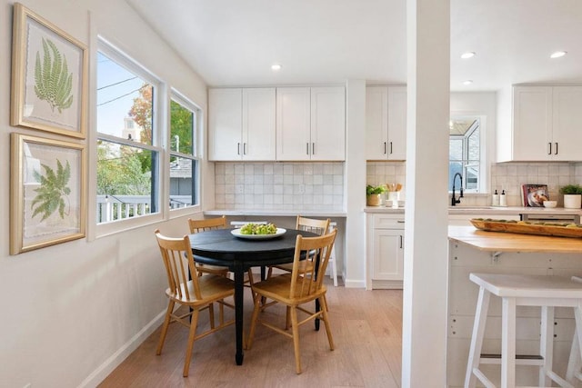 dining space with sink and light wood-type flooring