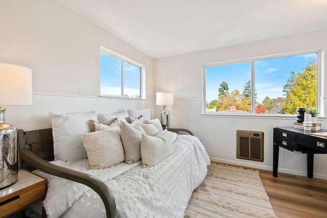 bedroom with heating unit and light hardwood / wood-style floors