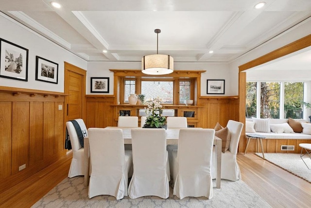 dining room with beamed ceiling, coffered ceiling, and light hardwood / wood-style floors