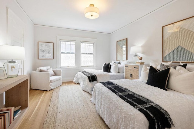 bedroom with crown molding and light wood-type flooring