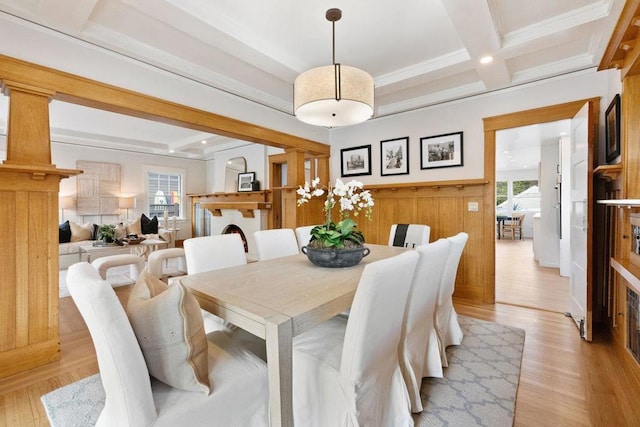 dining area featuring beamed ceiling, decorative columns, ornamental molding, coffered ceiling, and light hardwood / wood-style flooring