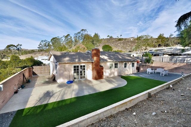 back of property featuring french doors, a patio area, and a yard