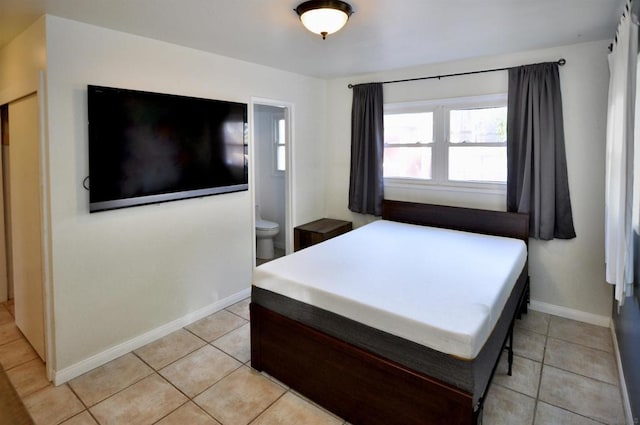 bedroom with connected bathroom and light tile patterned floors