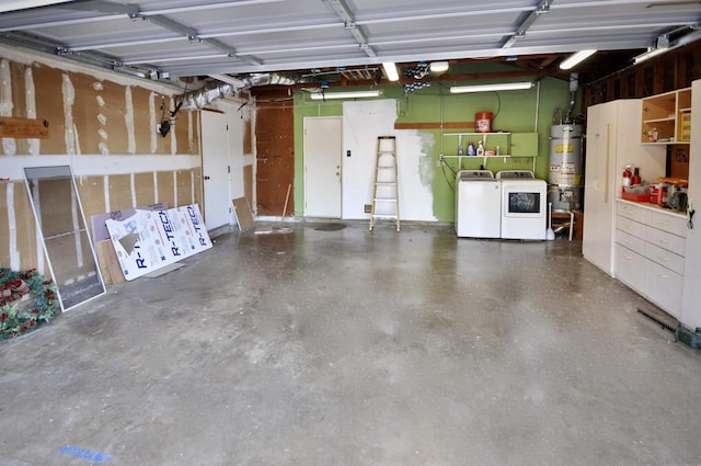 garage with strapped water heater and independent washer and dryer