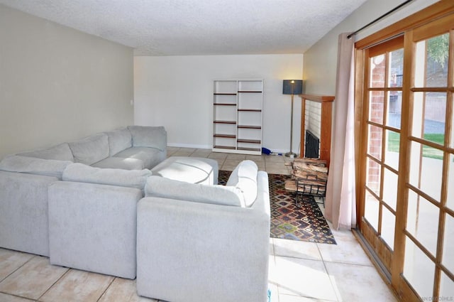 living room featuring a fireplace, a textured ceiling, and light tile patterned flooring