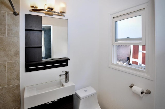 bathroom with sink, toilet, and a wealth of natural light