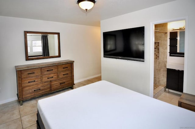 bedroom with light tile patterned floors and ensuite bath