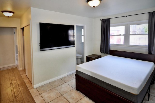 bedroom with connected bathroom and light tile patterned floors