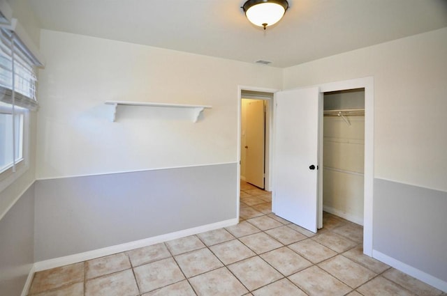 unfurnished bedroom with a closet and light tile patterned floors