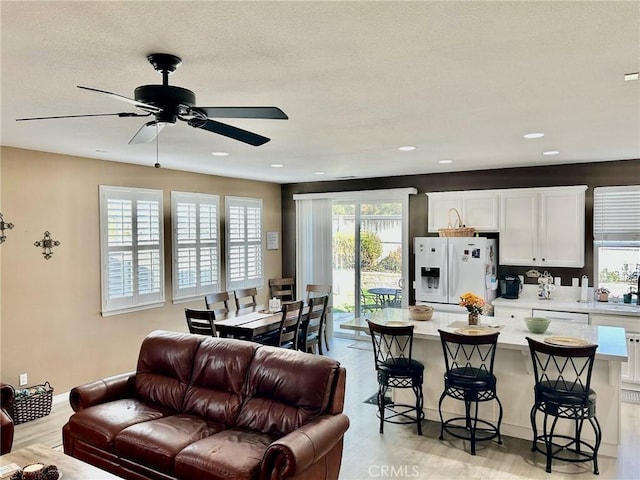 living room featuring ceiling fan and light hardwood / wood-style floors