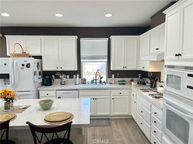 kitchen featuring sink, white appliances, white cabinets, and light hardwood / wood-style floors