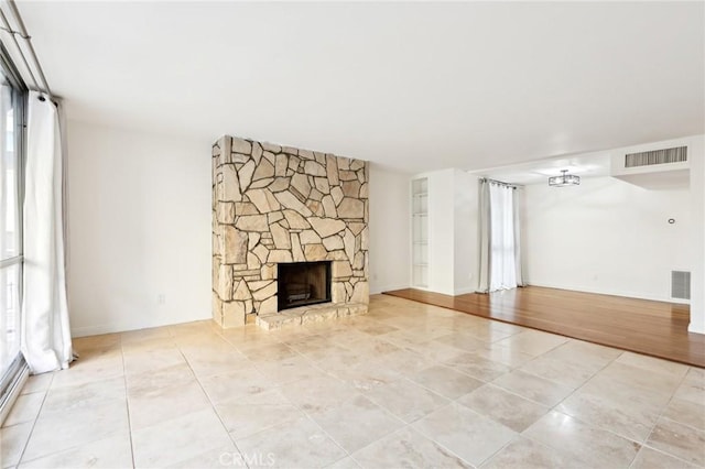 unfurnished living room with a stone fireplace