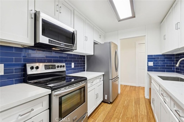 kitchen with sink, white cabinets, and stainless steel appliances