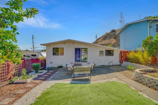 back of property with a yard and a patio area