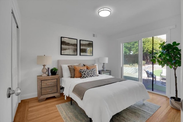 bedroom with access to exterior and light wood-type flooring