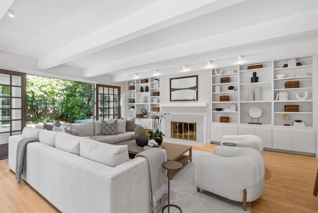 living room with light hardwood / wood-style flooring and beam ceiling