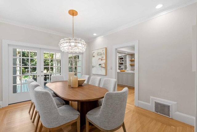 dining area featuring crown molding, french doors, and an inviting chandelier