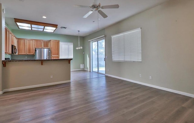 unfurnished living room featuring ceiling fan and dark hardwood / wood-style floors